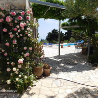 10 The Buoys Villa rose clad main porch and outside dining area.